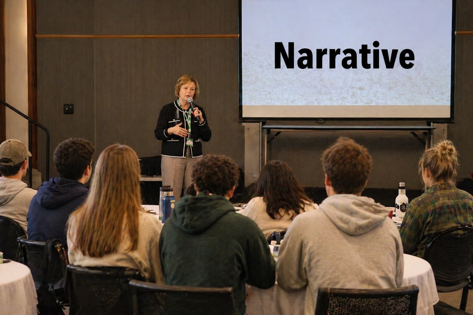 A speaker presenting to an audience in a classroom setting.